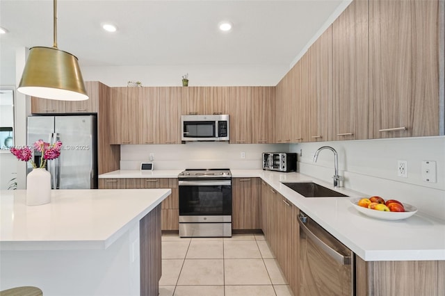 kitchen with light brown cabinetry, sink, hanging light fixtures, light tile patterned floors, and appliances with stainless steel finishes