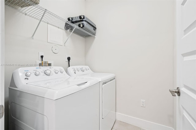 clothes washing area featuring washing machine and clothes dryer and light tile patterned floors