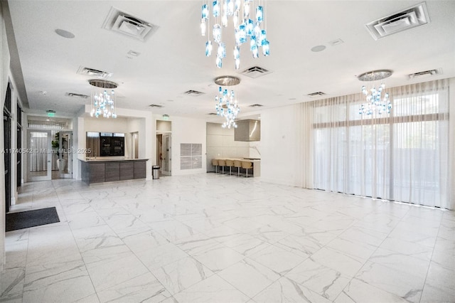 unfurnished living room with an inviting chandelier