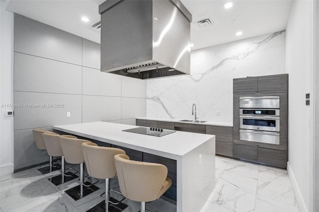 kitchen with sink, a kitchen breakfast bar, island exhaust hood, black electric stovetop, and oven