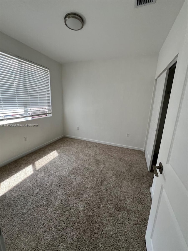 unfurnished bedroom with dark colored carpet