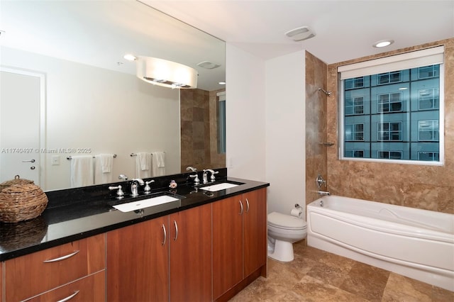 full bathroom with tiled shower / bath, vanity, and toilet