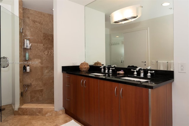 bathroom with tiled shower, vanity, and tile patterned floors