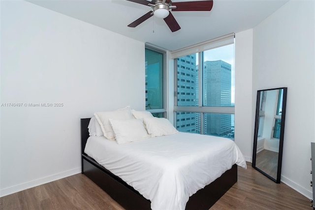 bedroom with dark wood-type flooring, ceiling fan, and floor to ceiling windows