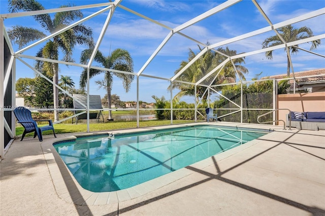 view of swimming pool with a yard, a patio area, and glass enclosure