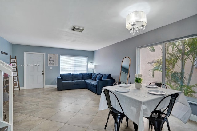 dining space featuring light tile patterned floors and a notable chandelier