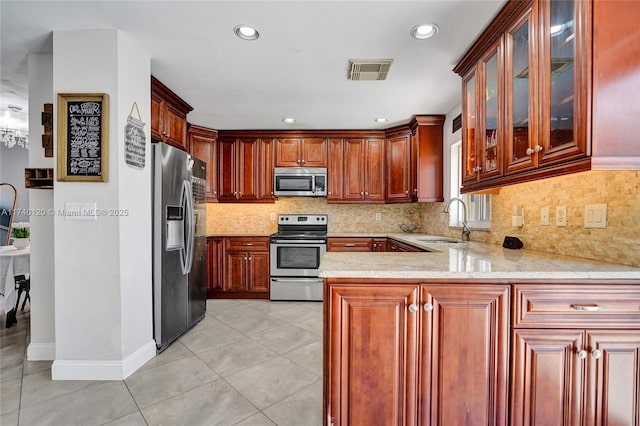 kitchen featuring appliances with stainless steel finishes, kitchen peninsula, sink, and light tile patterned floors