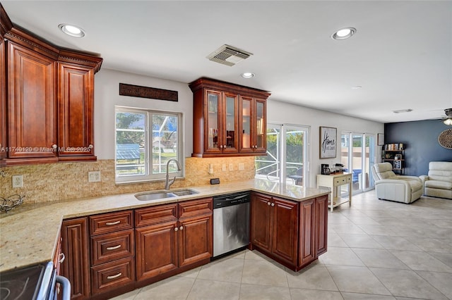 kitchen featuring dishwasher, sink, decorative backsplash, light tile patterned floors, and light stone countertops