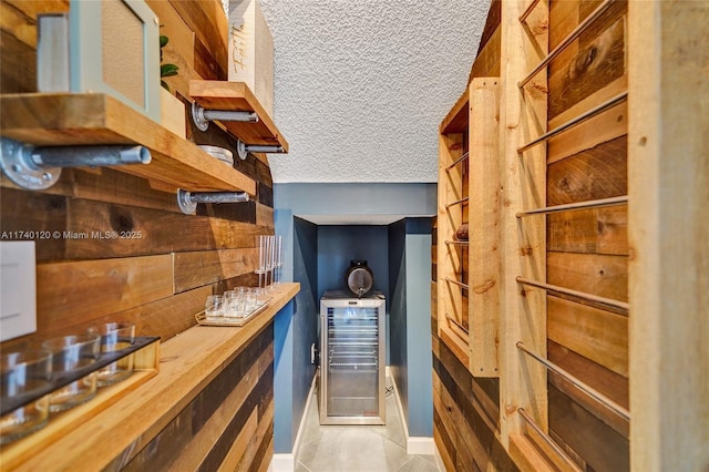 bar with wooden counters and a textured ceiling