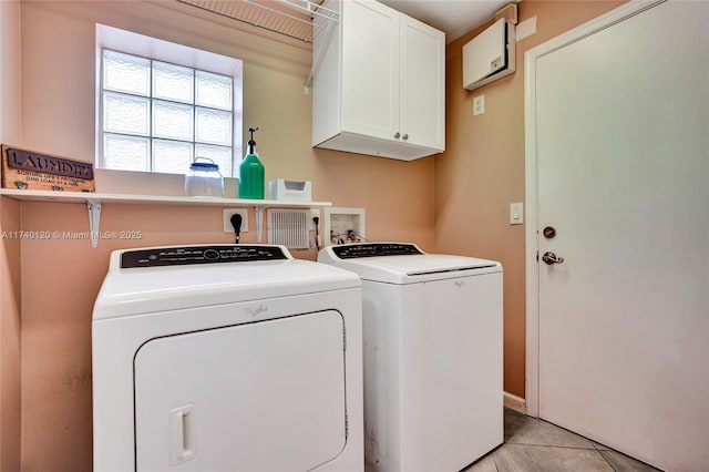 laundry area with cabinets, washer and dryer, and light tile patterned floors