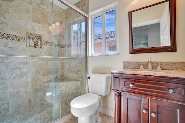 bathroom featuring a shower with door, vanity, and toilet