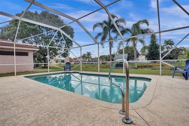 view of pool with a patio, glass enclosure, and a lawn