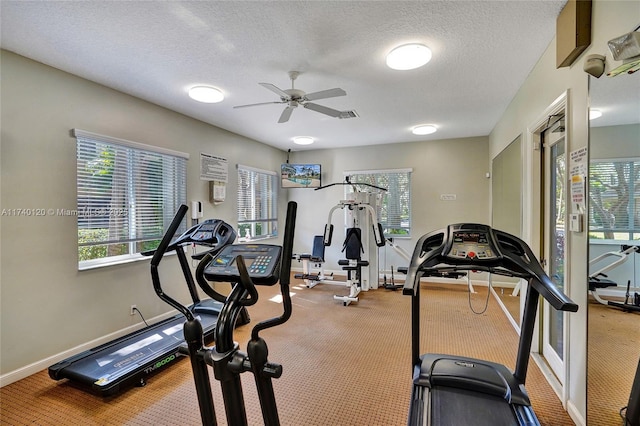 workout area featuring ceiling fan and a textured ceiling