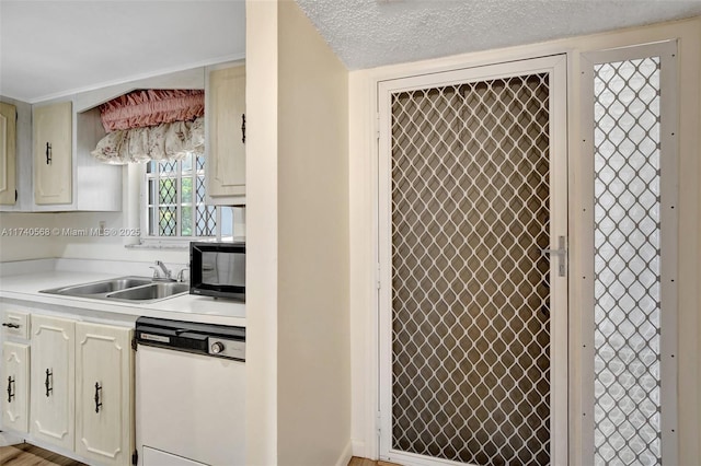 kitchen featuring sink, a textured ceiling, and white dishwasher