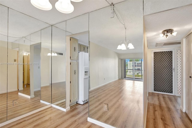 interior space featuring hardwood / wood-style flooring, a textured ceiling, and an inviting chandelier