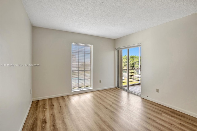 unfurnished room featuring a textured ceiling and light wood-type flooring