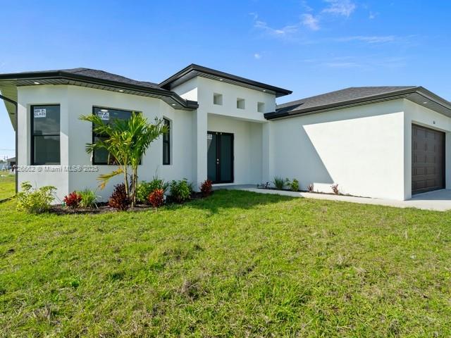 back of house with a yard and a garage