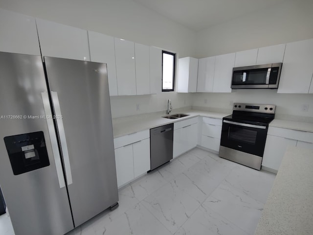 kitchen featuring stainless steel appliances, white cabinetry, and sink