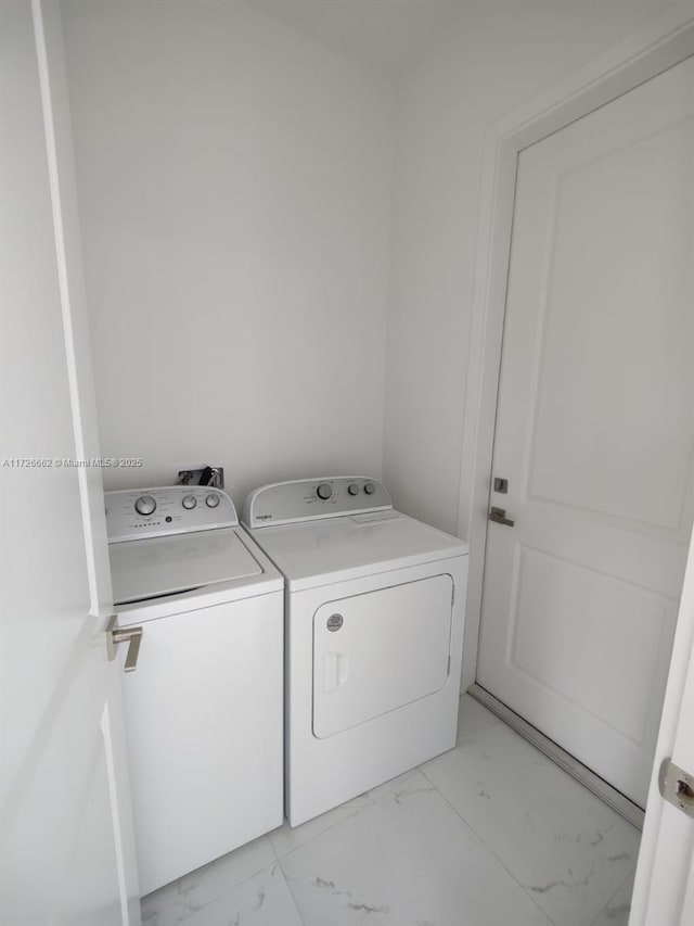 clothes washing area with washing machine and dryer