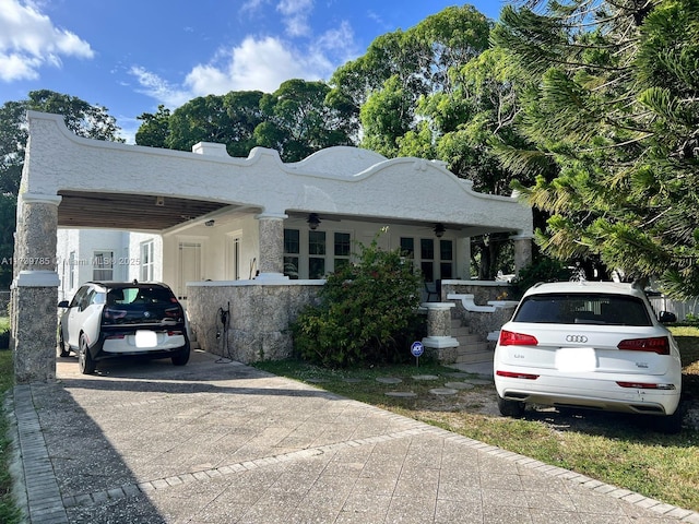 view of front facade featuring ceiling fan and a carport