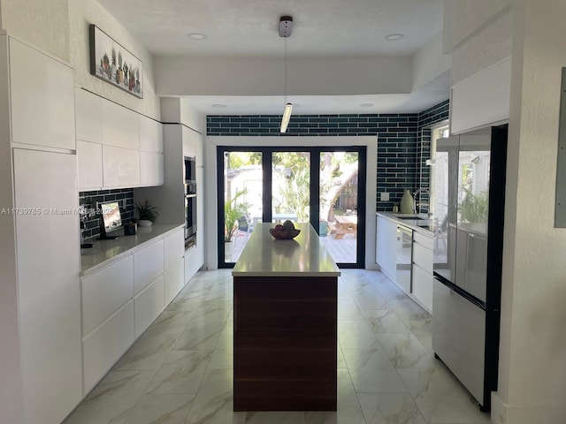 kitchen featuring dishwasher, a center island, white cabinets, and decorative light fixtures