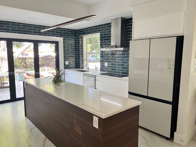 kitchen with sink, white cabinetry, refrigerator, dishwasher, and wall chimney range hood