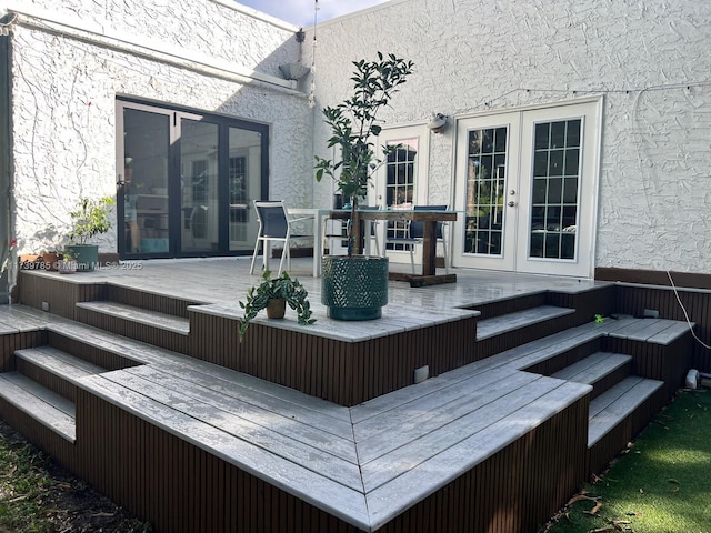 wooden deck with french doors and outdoor dining area