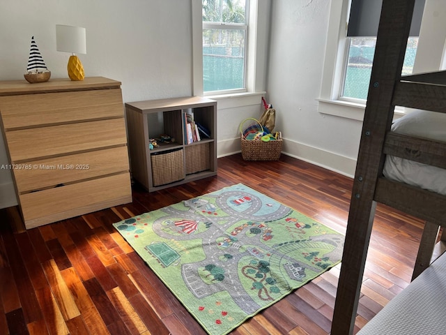 bedroom with dark wood-style floors and baseboards