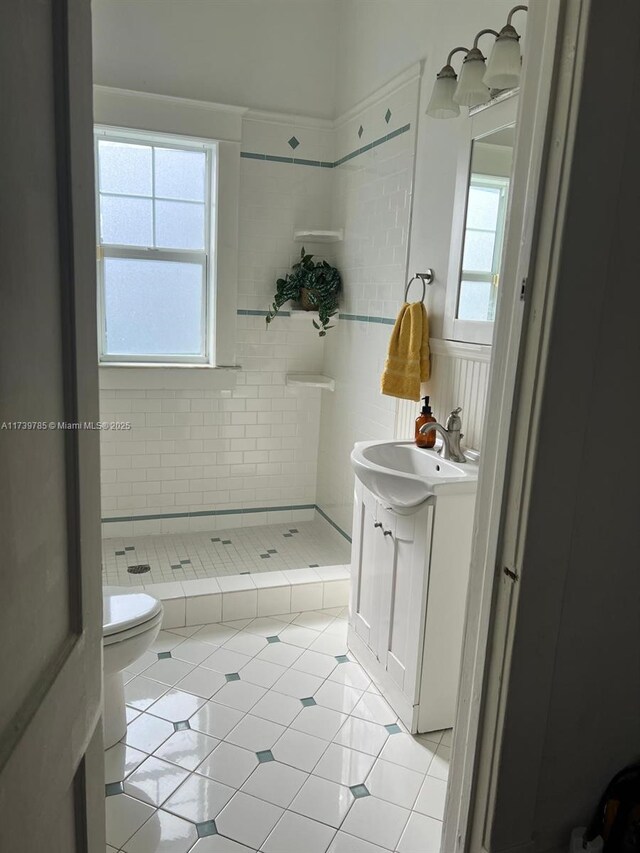 bathroom with tile patterned flooring, tiled shower, and toilet