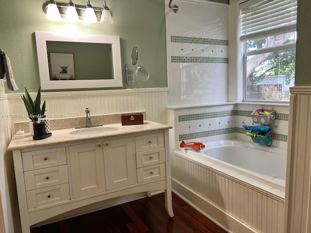 bathroom with vanity, a bathing tub, and hardwood / wood-style floors