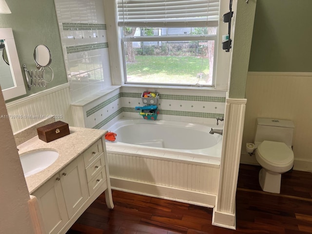 bathroom featuring vanity, a tub, hardwood / wood-style floors, and toilet