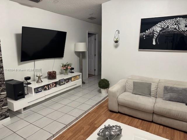 living room featuring a textured ceiling and light hardwood / wood-style floors