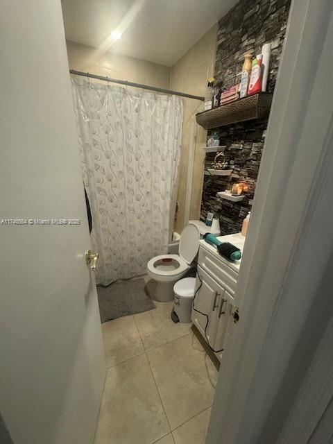 bathroom featuring vanity, tile patterned floors, and toilet