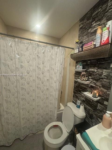 bathroom with shower / bath combo with shower curtain and toilet