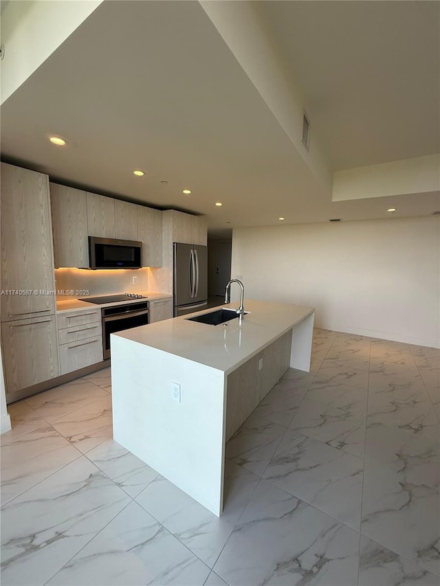 kitchen featuring sink, an island with sink, and appliances with stainless steel finishes