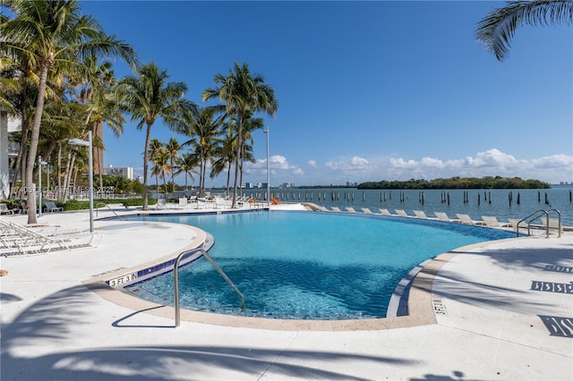 view of pool featuring a patio and a water view