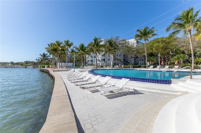 view of swimming pool with a water view and a patio area