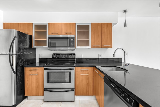 kitchen with dark stone countertops, sink, decorative light fixtures, and stainless steel appliances