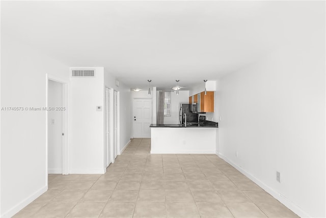 kitchen featuring stainless steel refrigerator and kitchen peninsula