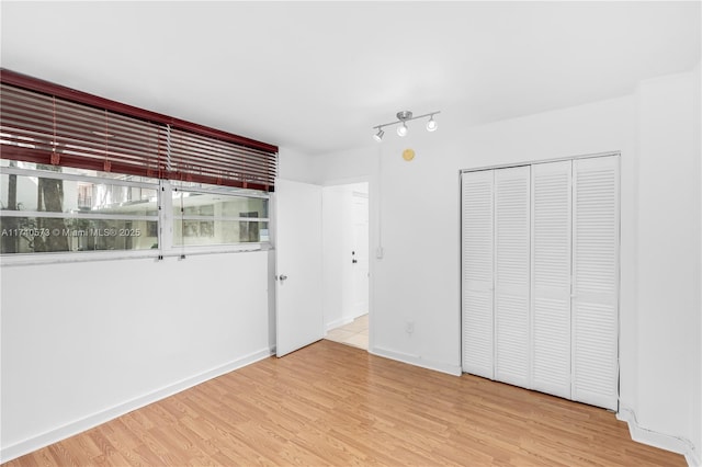 unfurnished bedroom with light hardwood / wood-style flooring and a closet