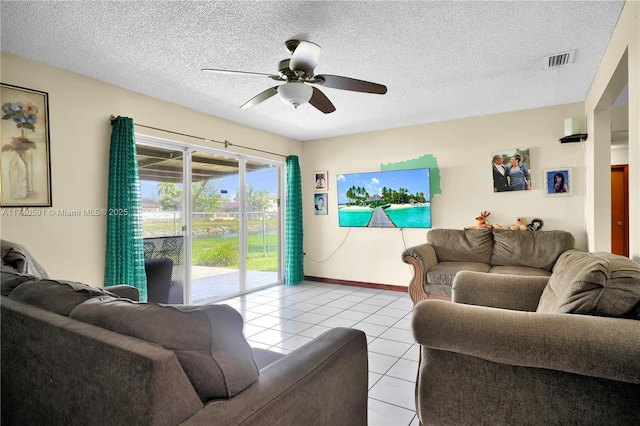 living room with light tile patterned flooring, ceiling fan, and a textured ceiling