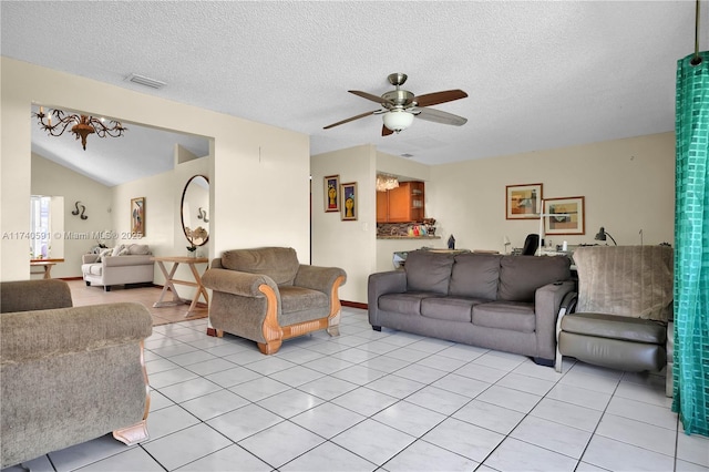 living room featuring lofted ceiling, ceiling fan, a textured ceiling, and light tile patterned flooring