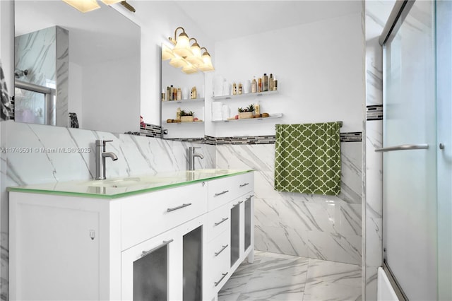 bathroom featuring a shower with door, vanity, and tile walls