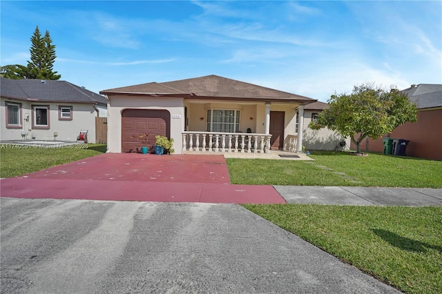 ranch-style house featuring a garage, covered porch, and a front lawn