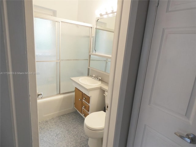 bathroom with enclosed tub / shower combo, vanity, and toilet