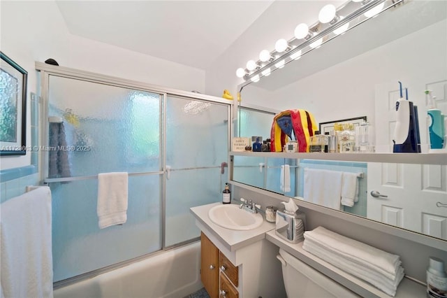 bathroom featuring toilet, shower / bath combination with glass door, and vanity