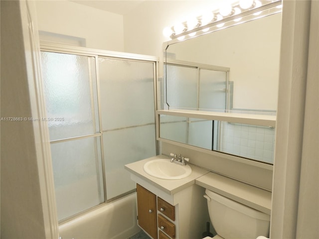 full bathroom featuring combined bath / shower with glass door, vanity, and toilet