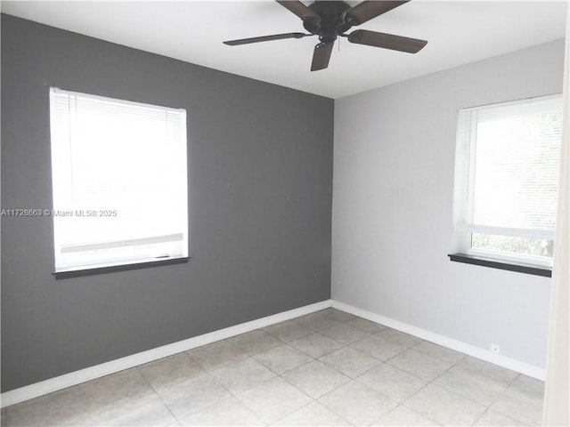 spare room with ceiling fan and baseboards