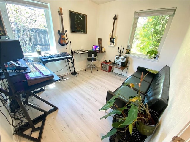 sitting room featuring light wood finished floors, plenty of natural light, and baseboards