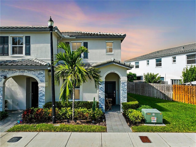 mediterranean / spanish home with a lawn